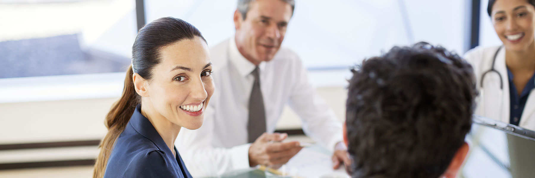 hospital administrator smiling during conference table meeting