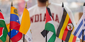 several international flags in front of student wearing indiana shirt