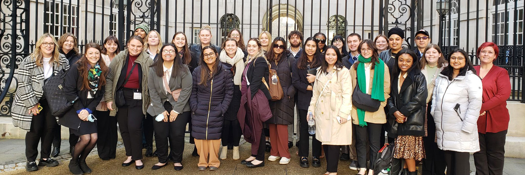 study abroad students posing in front of gate in london
