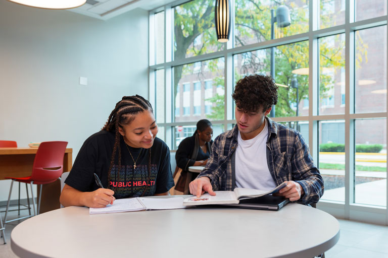 two public health students studying together in the health sciences building
