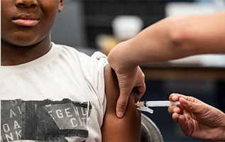 child receiving shot in upper left arm